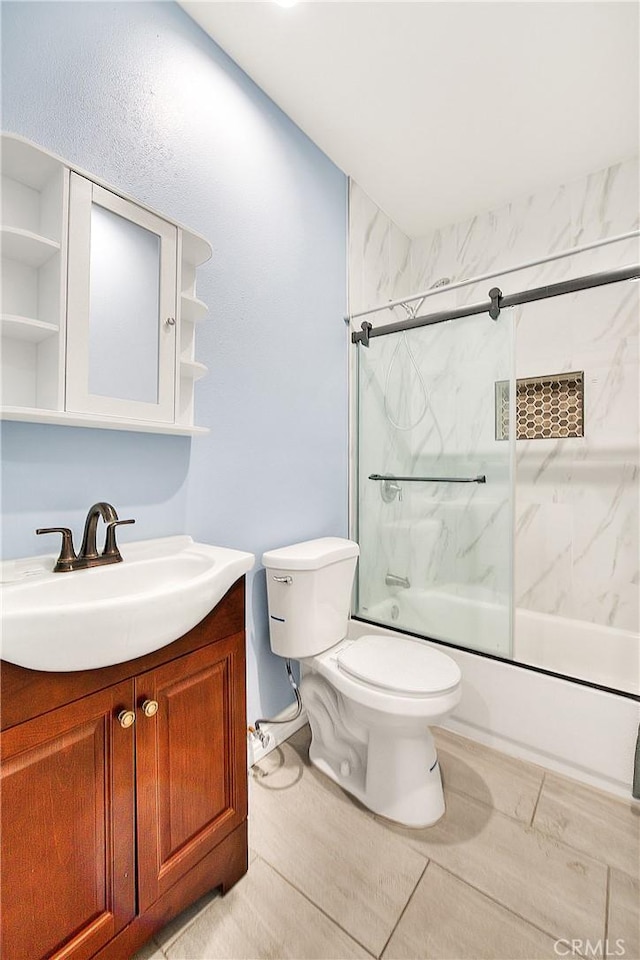 bathroom featuring toilet, vanity, and combined bath / shower with glass door