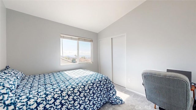 carpeted bedroom featuring vaulted ceiling and a closet