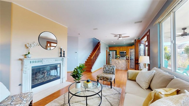 living room with ceiling fan and light hardwood / wood-style floors