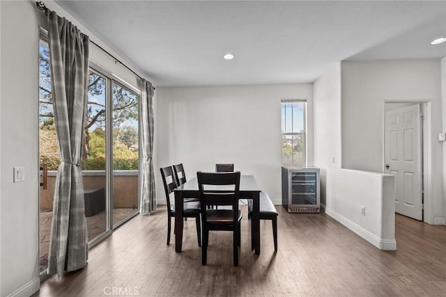 dining room with wine cooler, recessed lighting, dark wood finished floors, and baseboards