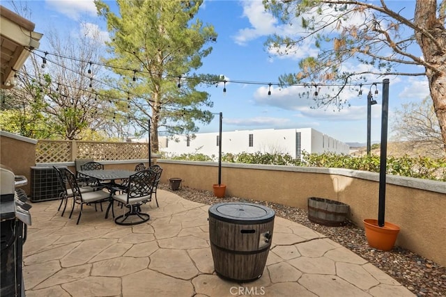 view of patio featuring outdoor dining space, central AC unit, and a grill