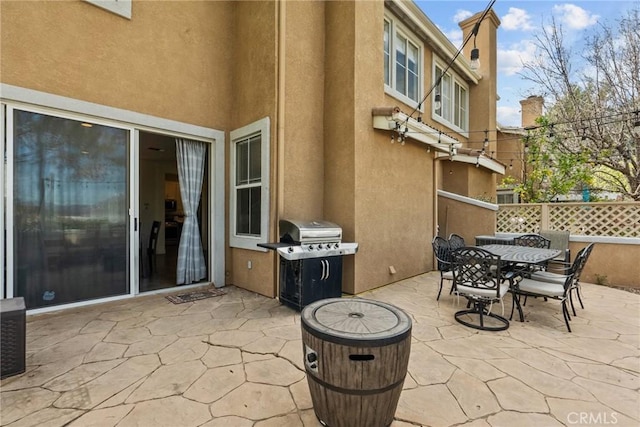 view of patio featuring outdoor dining space, area for grilling, and fence