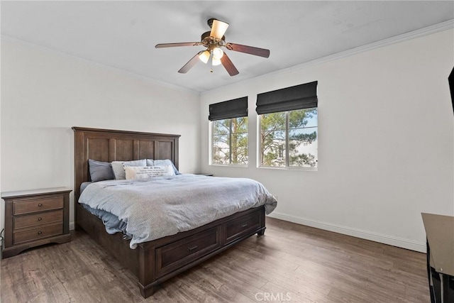 bedroom with baseboards, ornamental molding, ceiling fan, and wood finished floors