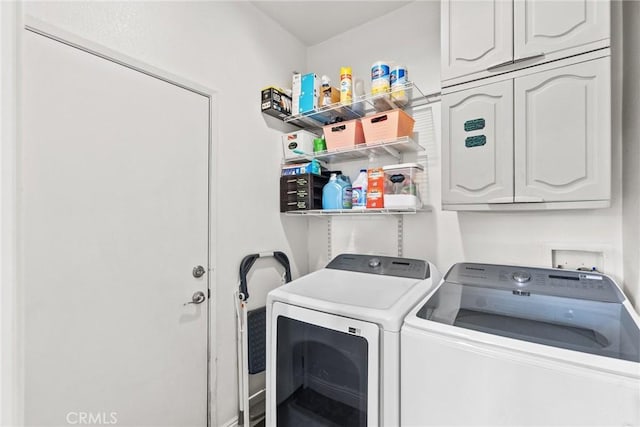 laundry area with washing machine and clothes dryer and cabinet space