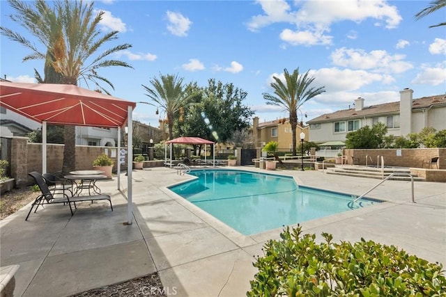 community pool featuring a patio area, fence, and a gazebo