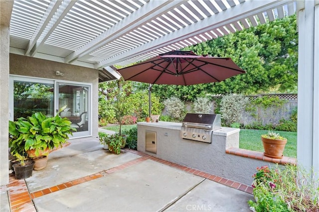 view of patio / terrace with exterior kitchen, fence, a pergola, and area for grilling