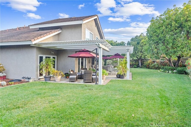 back of property with a patio area, stucco siding, a lawn, and a pergola