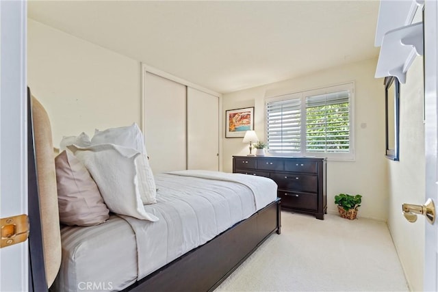 bedroom with light carpet and a closet