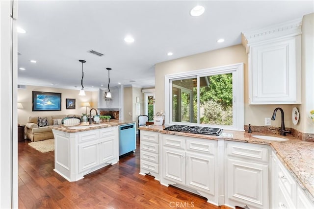 kitchen with stainless steel appliances, a sink, visible vents, white cabinetry, and open floor plan