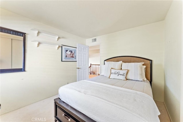 bedroom featuring visible vents and light colored carpet