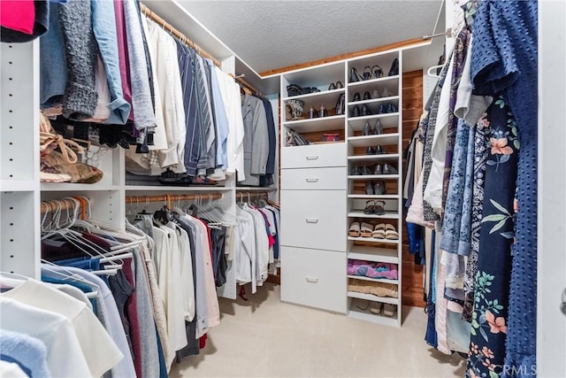 walk in closet with light carpet