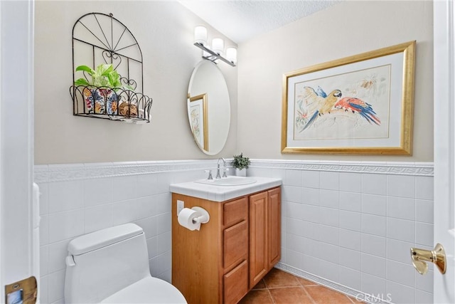 bathroom with a wainscoted wall, tile walls, and tile patterned floors