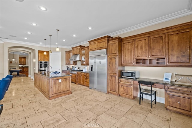 kitchen featuring a center island with sink, dark stone countertops, sink, appliances with stainless steel finishes, and pendant lighting