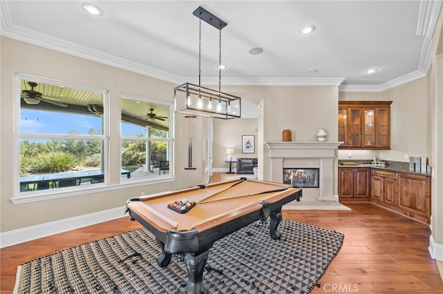 game room with light hardwood / wood-style floors, billiards, and ornamental molding