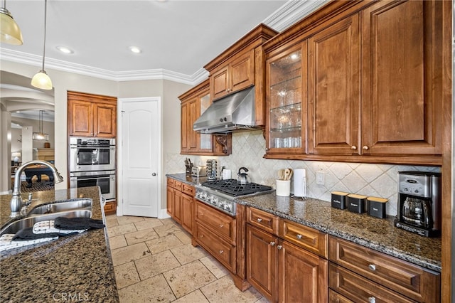 kitchen with appliances with stainless steel finishes, dark stone counters, decorative light fixtures, backsplash, and sink