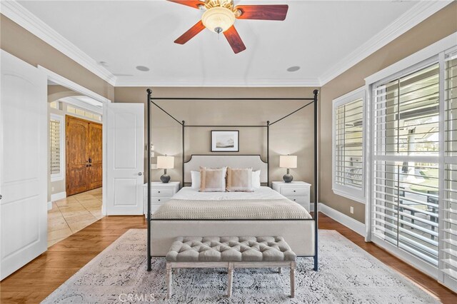 bedroom featuring ceiling fan, light wood-type flooring, and crown molding