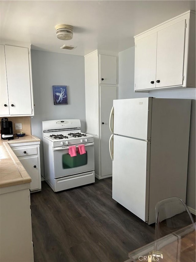 kitchen with white cabinetry, white appliances, and dark hardwood / wood-style flooring