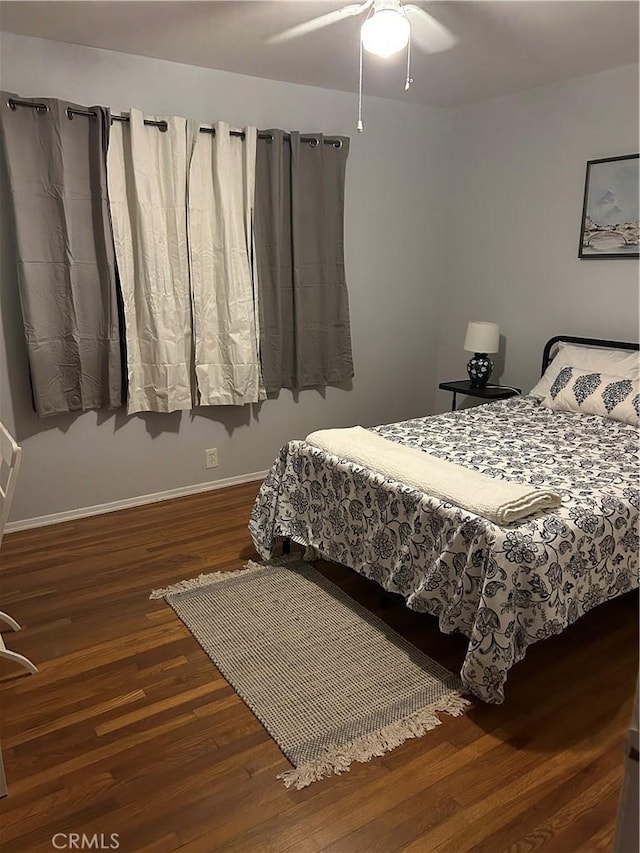 bedroom with dark hardwood / wood-style flooring and ceiling fan