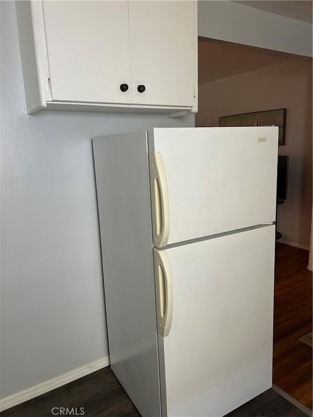 kitchen with white cabinetry, dark wood-type flooring, and white refrigerator