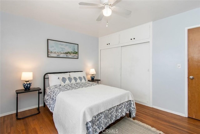 bedroom featuring a closet, baseboards, wood finished floors, and a ceiling fan