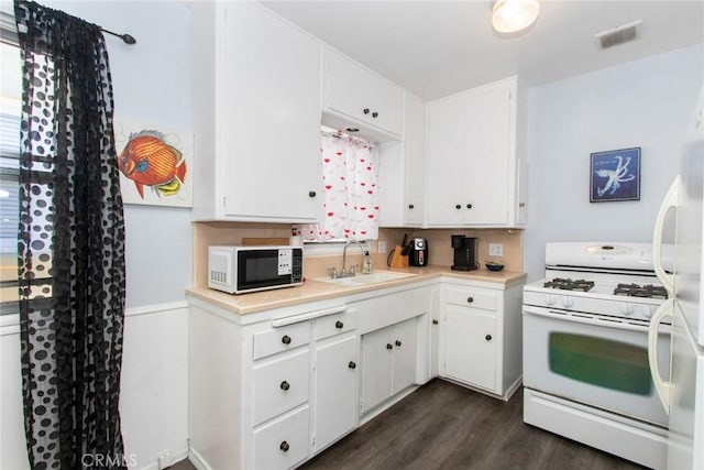 kitchen featuring a sink, dark wood-style floors, white cabinetry, white appliances, and light countertops