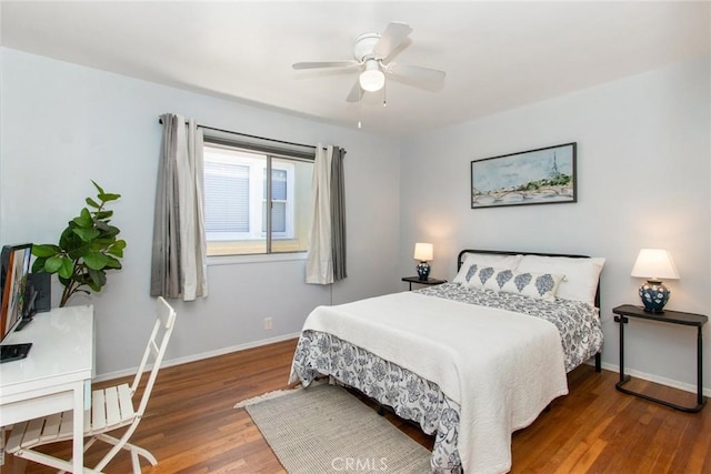 bedroom featuring ceiling fan, baseboards, and wood finished floors