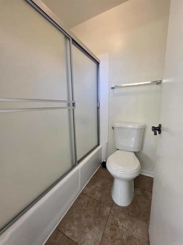 full bathroom with combined bath / shower with glass door, toilet, and tile patterned floors