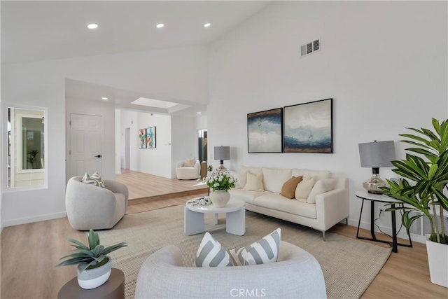 living room featuring light hardwood / wood-style floors and high vaulted ceiling