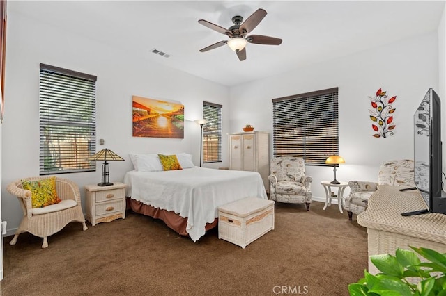 bedroom featuring baseboards, a ceiling fan, visible vents, and carpet