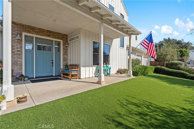 doorway to property featuring a lawn, board and batten siding, and brick siding