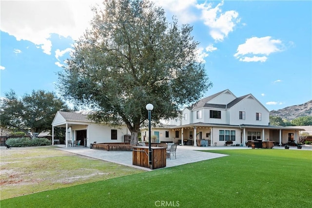 rear view of property with a patio area, a jacuzzi, a lawn, and a bar