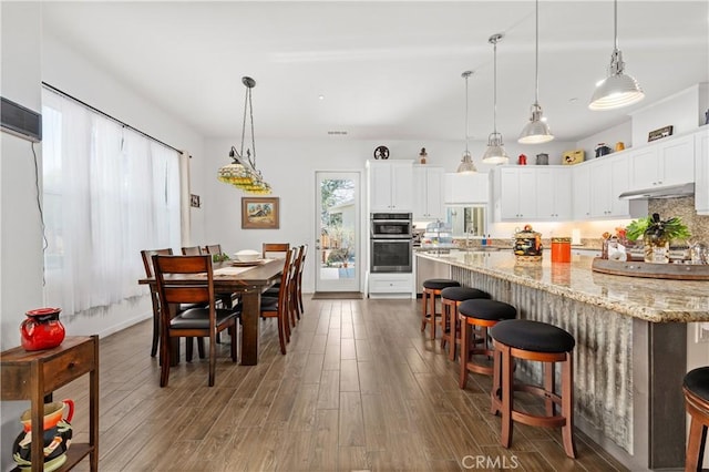 dining area with baseboards and wood finished floors