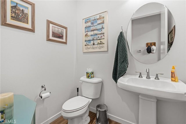 bathroom featuring sink, toilet, and wood-type flooring