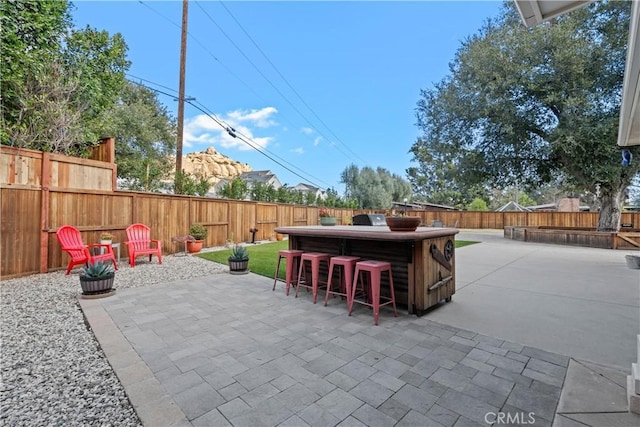 view of patio with a fenced backyard and outdoor dry bar