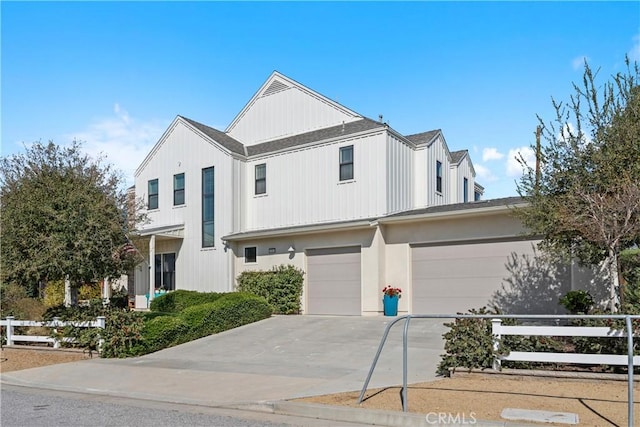 view of front facade with an attached garage, fence, and concrete driveway