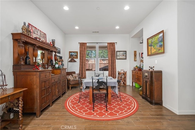 dining area featuring wood tiled floor, visible vents, baseboards, and recessed lighting