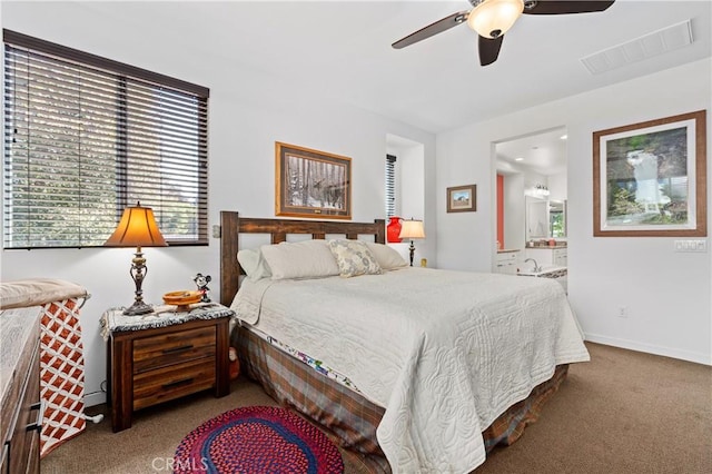 bedroom with ensuite bathroom, visible vents, baseboards, ceiling fan, and carpet floors