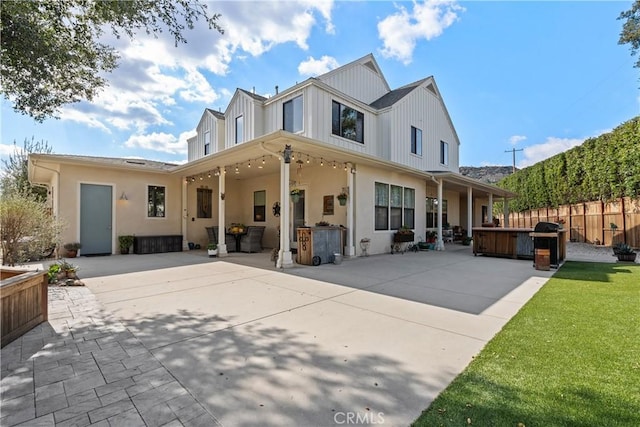 rear view of house with a patio area and a hot tub