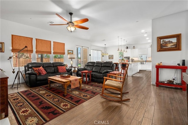 living room with dark wood-type flooring and ceiling fan