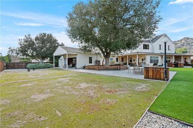 rear view of house with a yard, exterior bar, and a patio