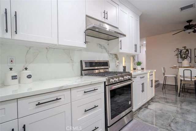 kitchen featuring white cabinets, tasteful backsplash, stainless steel gas range, and ceiling fan