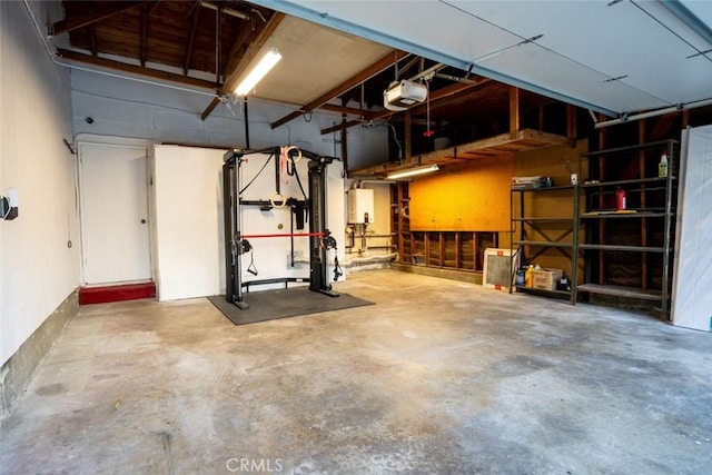 garage featuring a garage door opener and tankless water heater