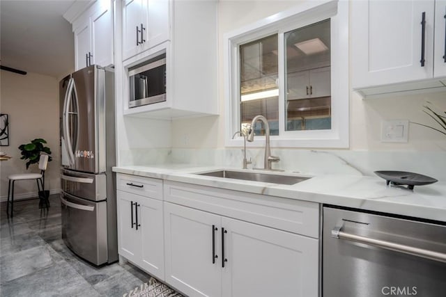 kitchen with white cabinetry, stainless steel appliances, and sink