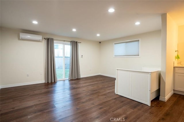 interior space with dark wood-type flooring and a wall mounted air conditioner