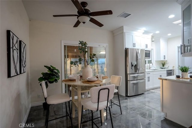 dining area featuring ceiling fan and sink