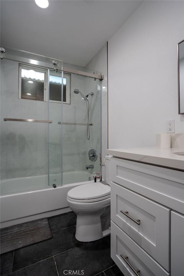 full bathroom featuring vanity, shower / bath combination with glass door, and toilet