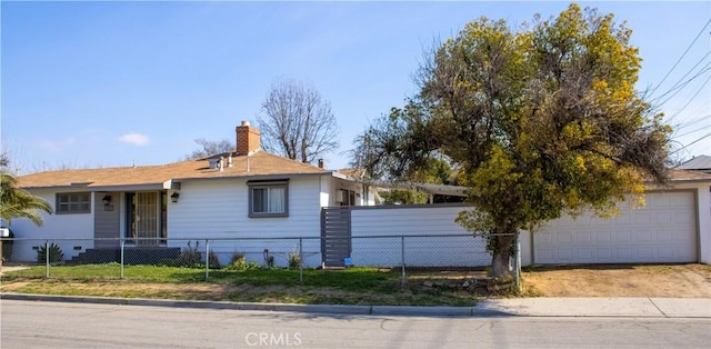 ranch-style home with driveway, a fenced front yard, a chimney, and an attached garage