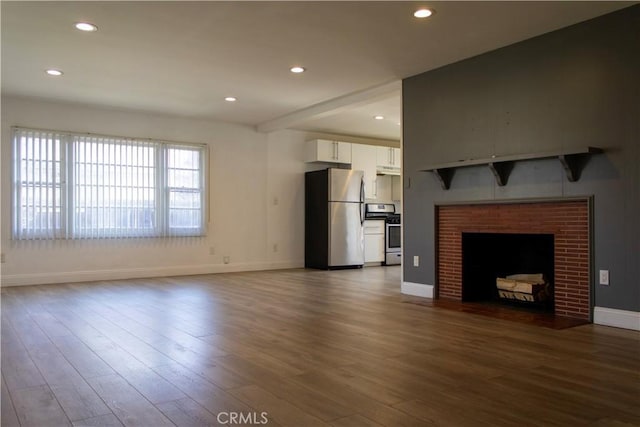 unfurnished living room featuring baseboards, a brick fireplace, dark wood finished floors, and recessed lighting