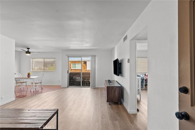 living room with light hardwood / wood-style flooring and ceiling fan