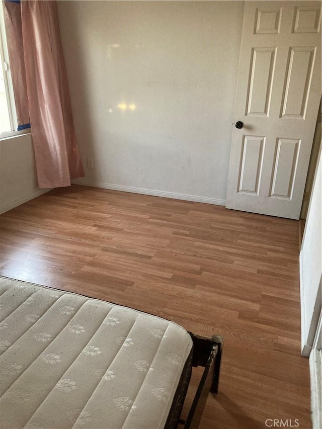 unfurnished bedroom with hardwood / wood-style flooring